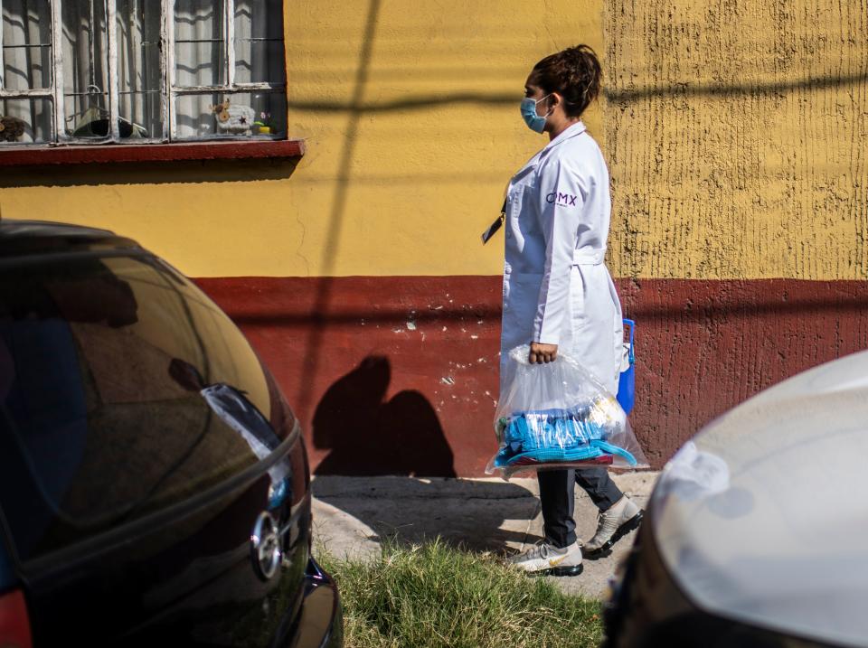 A health worker walks during door-to-door visits to carry out COVID-19 tests in Mexico City, on June 16, 2020, amid the new coronavirus pandemic. (Photo by PEDRO PARDO / AFP) (Photo by PEDRO PARDO/AFP via Getty Images)