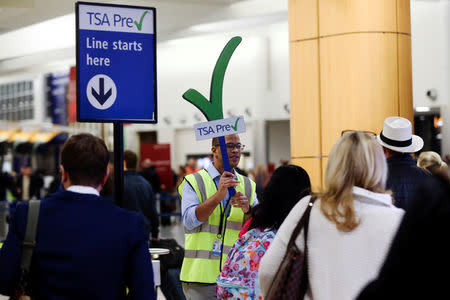 A man guides passengers towards a Transportation Security Administration (TSA) PreCheck security checkpoint at Hartsfield-Jackson Atlanta International Airport amid the partial federal government shutdown, in Atlanta, Georgia, U.S., January 18, 2019. REUTERS/Elijah Nouvelage