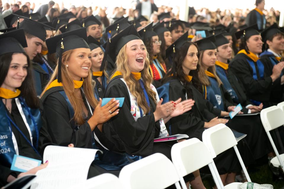 Salve Regina University graduates cheer on classmates as they receive their diplomas during the 74th Commencement in Newport.