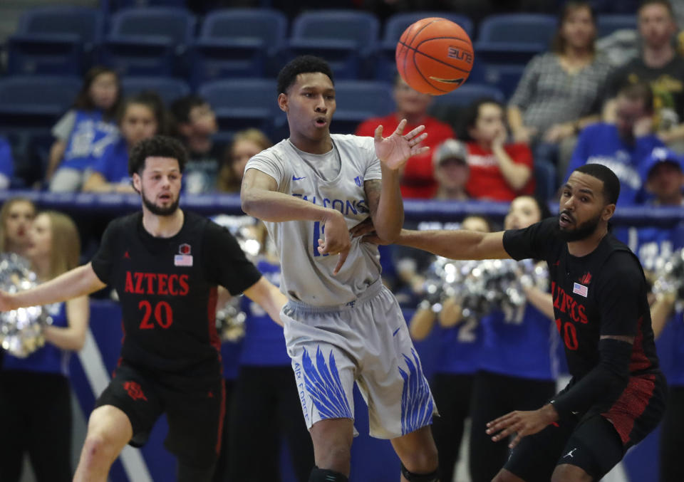 Air Force forward Lavelle Scottie, center, passes the ball as San Diego State guards Jordan Schakel, left, and KJ Feagin defend in the second half of an NCAA college basketball game Saturday, Feb. 8, 2020, at Air Force Academy, Colo. (AP Photo/David Zalubowski)