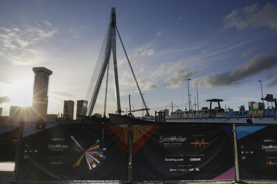 A fence blocks the view on the opening ceremony of Eurovision Song Contest as the sun sets over the iconic Erasmus bridge in the center of Rotterdam, Netherlands, Sunday, May 16, 2021. (AP Photo/Peter Dejong)