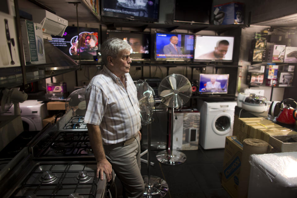 Jose Luis Guibelade, 65, waits for customers at his small appliance and electronics' store in Buenos Aires, Argentina, Monday, Jan. 27, 2014. Guibelade said that what he does not know what he will charge for most of his products since the majority of his suppliers don't know the new prices either, following the recent economic measures announced last Friday, Jan. 24, that allow Argentines to buy U.S. dollars for personal savings. (AP Photo/Victor R. Caivano)