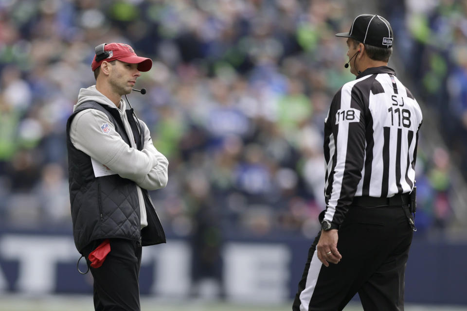 Arizona Cardinals head coach Jonathan Gannon, left, stares down an official during the first half of an NFL football game against the Seattle Seahawks Sunday, Oct. 22, 2023, in Seattle. (AP Photo/John Froschauer)