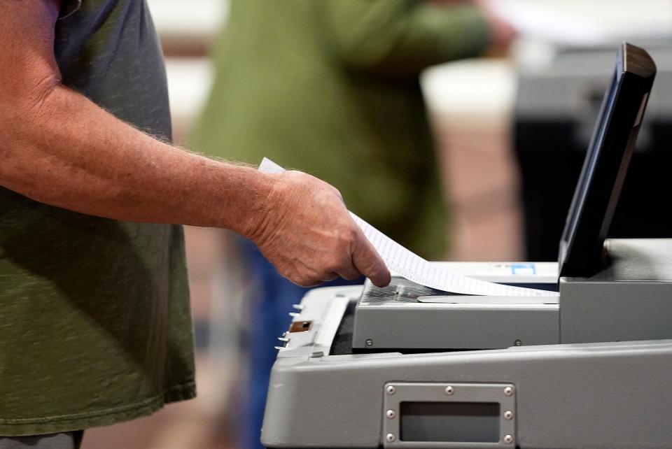 A voter turns in his ballot into the ballot counter during primary Election Day at Grove City Recreation Center in Grove City, Ohio on May 3, 2022. 