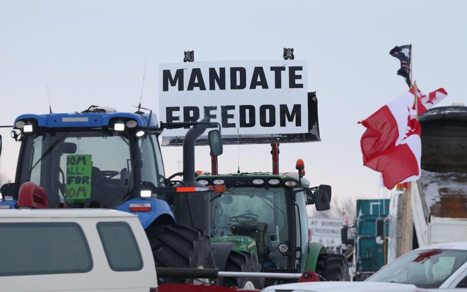 Trucks and tractors blockade the U.S.-Canada border crossing during a demonstration in Emerson, Manitoba, Canada, on Sunday, Feb. 13, 2022. Demonstrators have been blocking the Emerson border crossing since Feb. 10 in protest to the Canadian and American vaccine policy. Photographer: Shannon VanRaes/Bloomberg - Bloomberg