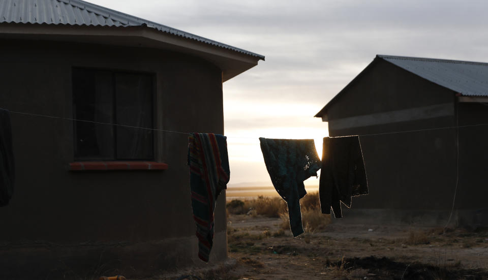 Sweaters hang on a clothing line as the sun sets in in the Urus del Lago Poopo Indigenous community, in Punaca, Bolivia, Sunday, May 23, 2021. Since the lake dried up about five years ago, the Uru — "people of the water" — are left clinging to its salt-crusted former shoreline scrabbling for ways to make a living. (AP Photo/Juan Karita)