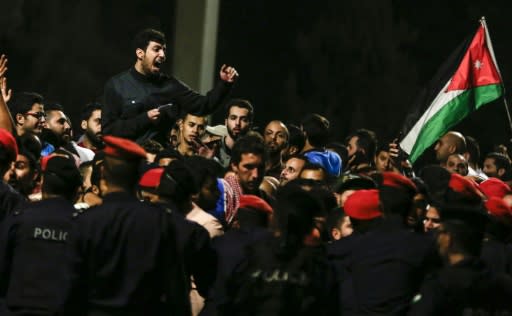 Jordanian protesters shout slogans and raise a national flag during a demonstration outside the Prime Minister's office in the capital Amman late on June 2, 2018