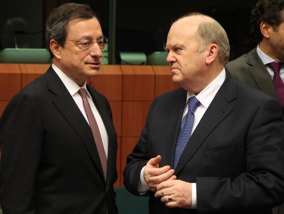 President of the European Central Bank Mario Draghi, left, talks with Irish Finance Minister Michael Noonan, during the Eurogroup finance ministers meeting in Brussels, Monday, Nov, 12, 2012. Greece’s international lenders have prepared a “positive” report on the country’s reform efforts, a crucial step in its efforts to secure the next installment of its bailout loan, the head the of group of finance ministers from the 17 euro countries said Monday. (AP Photo/Yves Logghe)