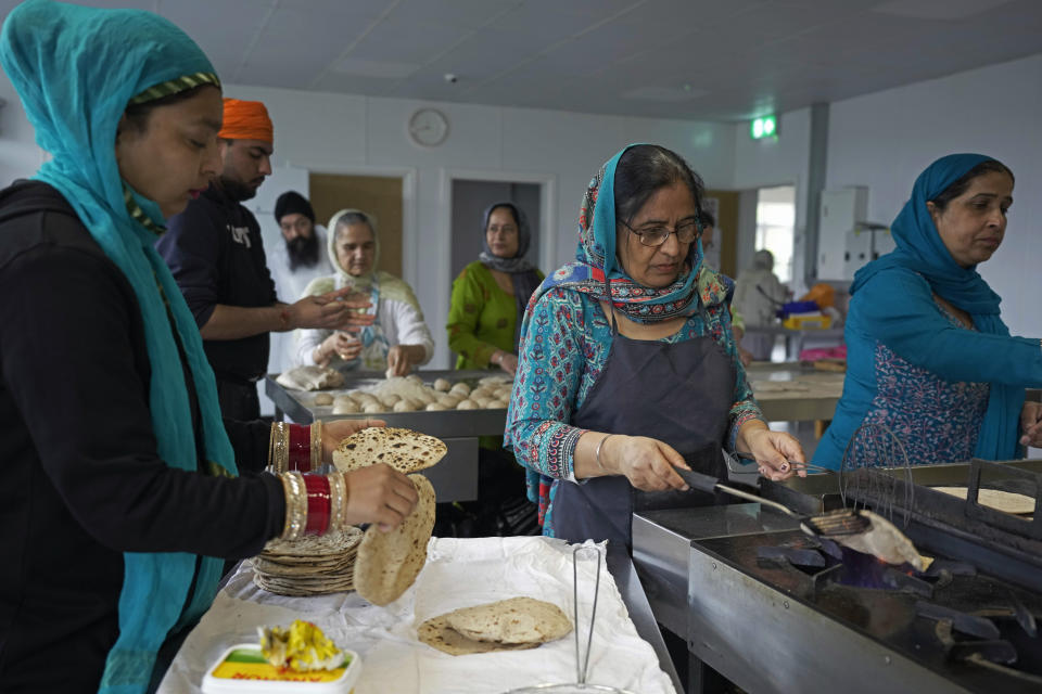 Sikh volunteers make the unleavened flatbread known as chapatis for the communal meal at the newly built Guru Nanak Gurdwara, in Luton, England, Thursday, April 27, 2023. King Charles III officially opened the Guru Nanak Gurdwara, a Sikh house of worship, in Luton last year. (AP Photo/Kin Cheung)