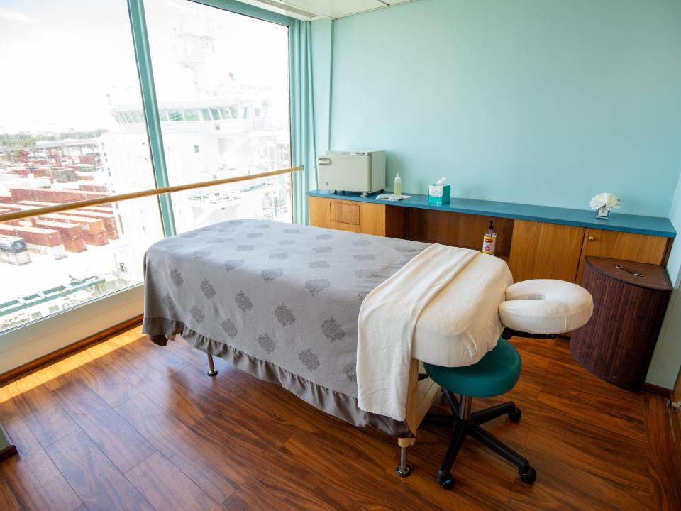 A massage chair in front of a large window.