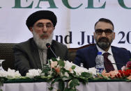 Afghan Warlord Gulbuddin Hekmatyar, leader of Islamist organization Hezb-i-Islami, left, delivers his speech while Ustad Atta Mohammad Noor, a leader of Jamiat-e-Islami looks on during an Afghan Peace Conference in Bhurban, 65 kilometers (40 miles) north of Islamabad, Pakistan, Saturday, June 22, 2019. Dozens of Afghan political leaders attended a peace conference in neighboring Pakistan on Saturday to pave the way for further Afghan-to-Afghan dialogue. (AP Photo/Anjum Naveed)