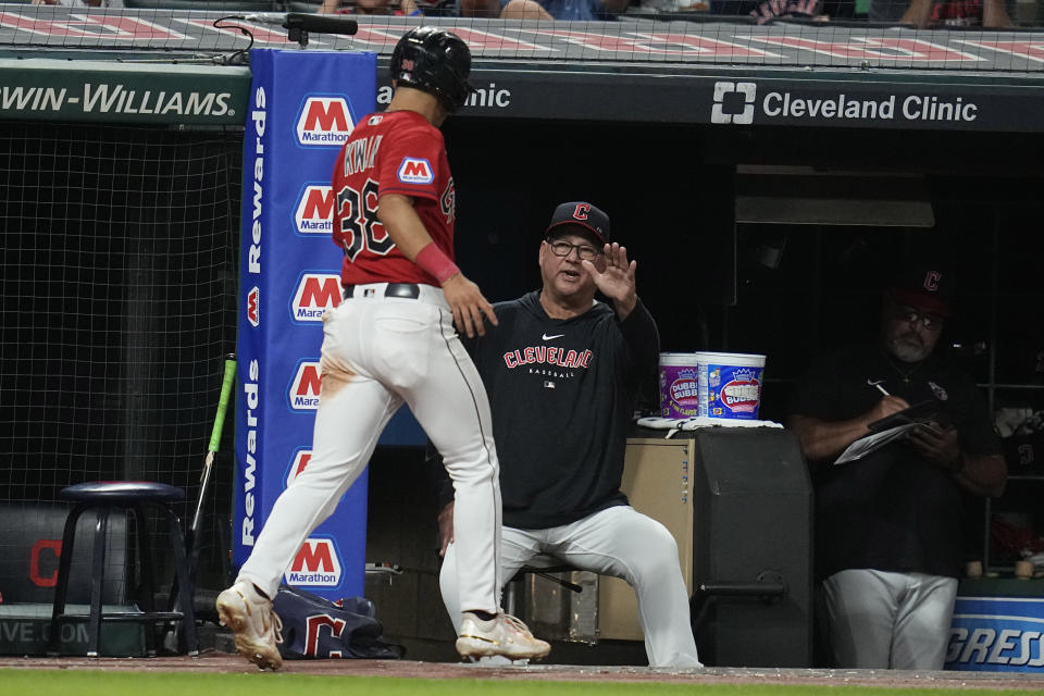 Cleveland Guardians' Steven Kwan (38) is greeted by manager Terry Francona, right, after scoring in the ninth inning of a baseball game against the Atlanta Braves, Wednesday, July 5, 2023, in Cleveland. (AP Photo/Sue Ogrocki)