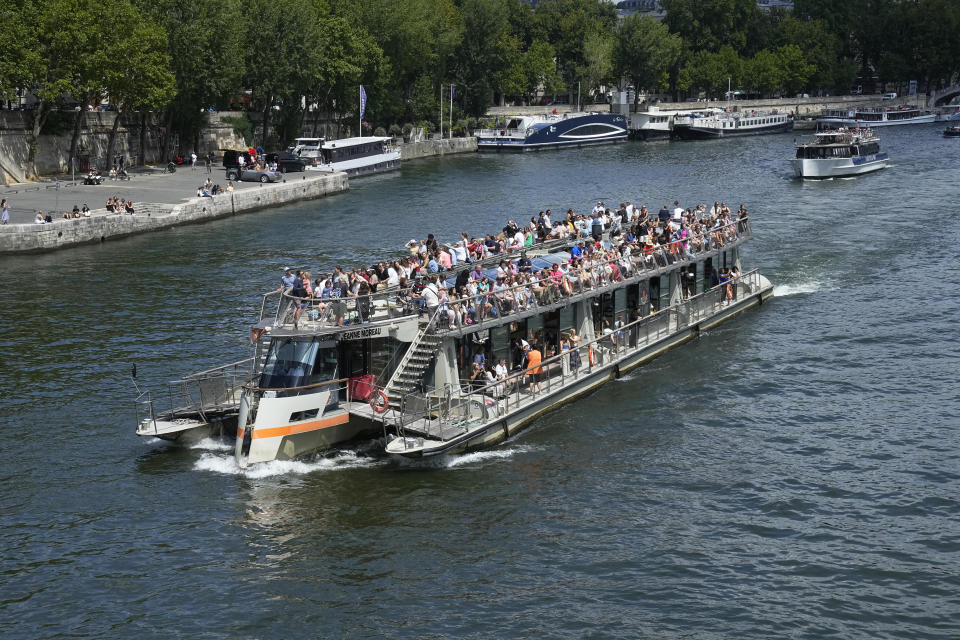 Tourists pack a barge on the Seine River Thursday, July 6, 2023 in Paris. French government officials met with representatives of the tourism industry to discuss repercussions of unrest sparked by the police killing of a 17-year-old boy on tourist activity and on France's international image. The shooting death of Nahel Merzouk, who was of north African descent, prompted nationwide anger over police tactics and entrenched discrimination against people in low-income neighborhoods around France where many trace their roots to former French colonies. (AP Photo/Michel Euler)