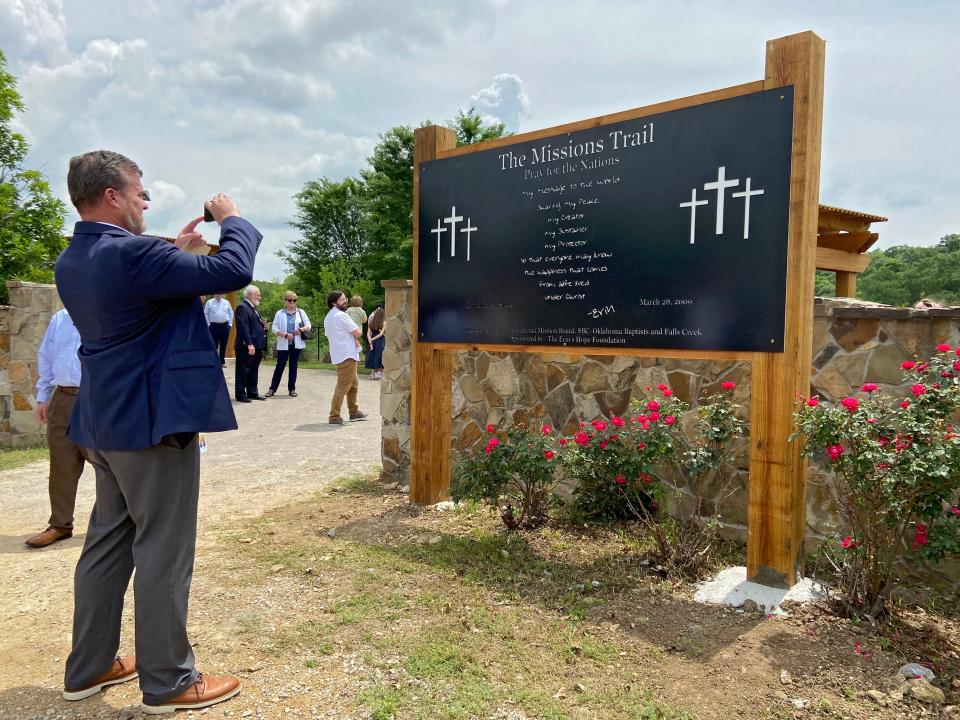 The Rev. Todd Fisher, executive director-treasurer of Oklahoma Baptists, takes a picture of a sign at the entrance of The Missions Trail located in the Centennial Prayer Garden at Falls Creek Baptist Camp & Conference Center near Davis.