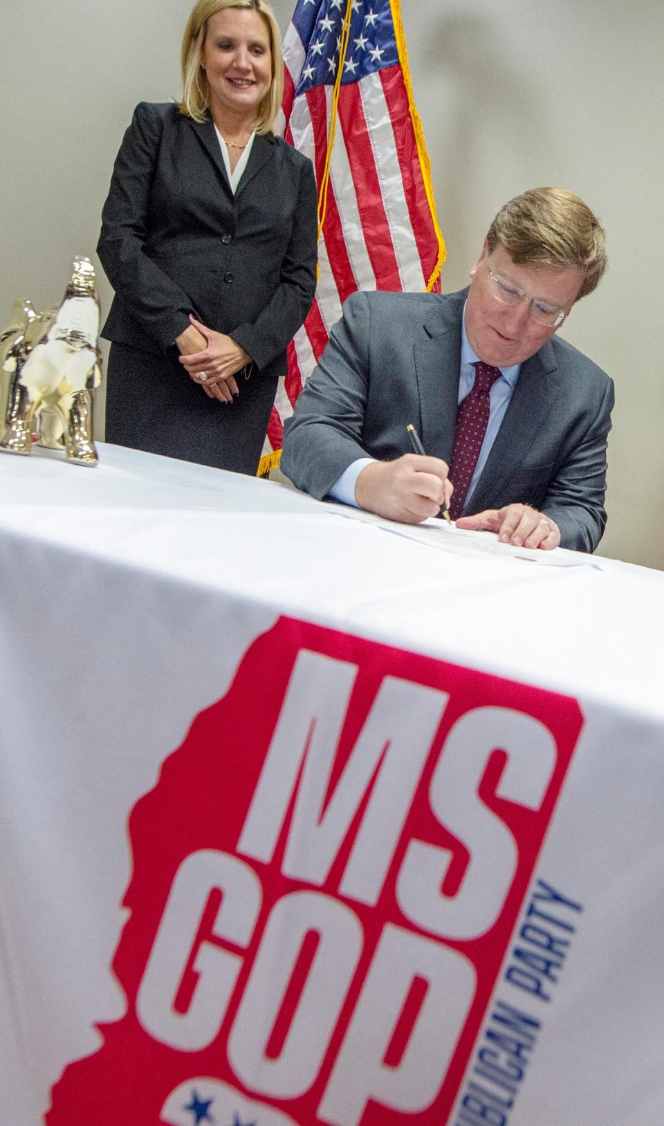 With his wife Elee Reeves at his side, Gov. Tate Reeves signs the Republican Candidate Party Nomination form to officially state his intent and qualifications to run for a second term as governor at the Mississippi Republican Headquarters in Jackson, Miss., Tuesday, Jan. 3, 2023.