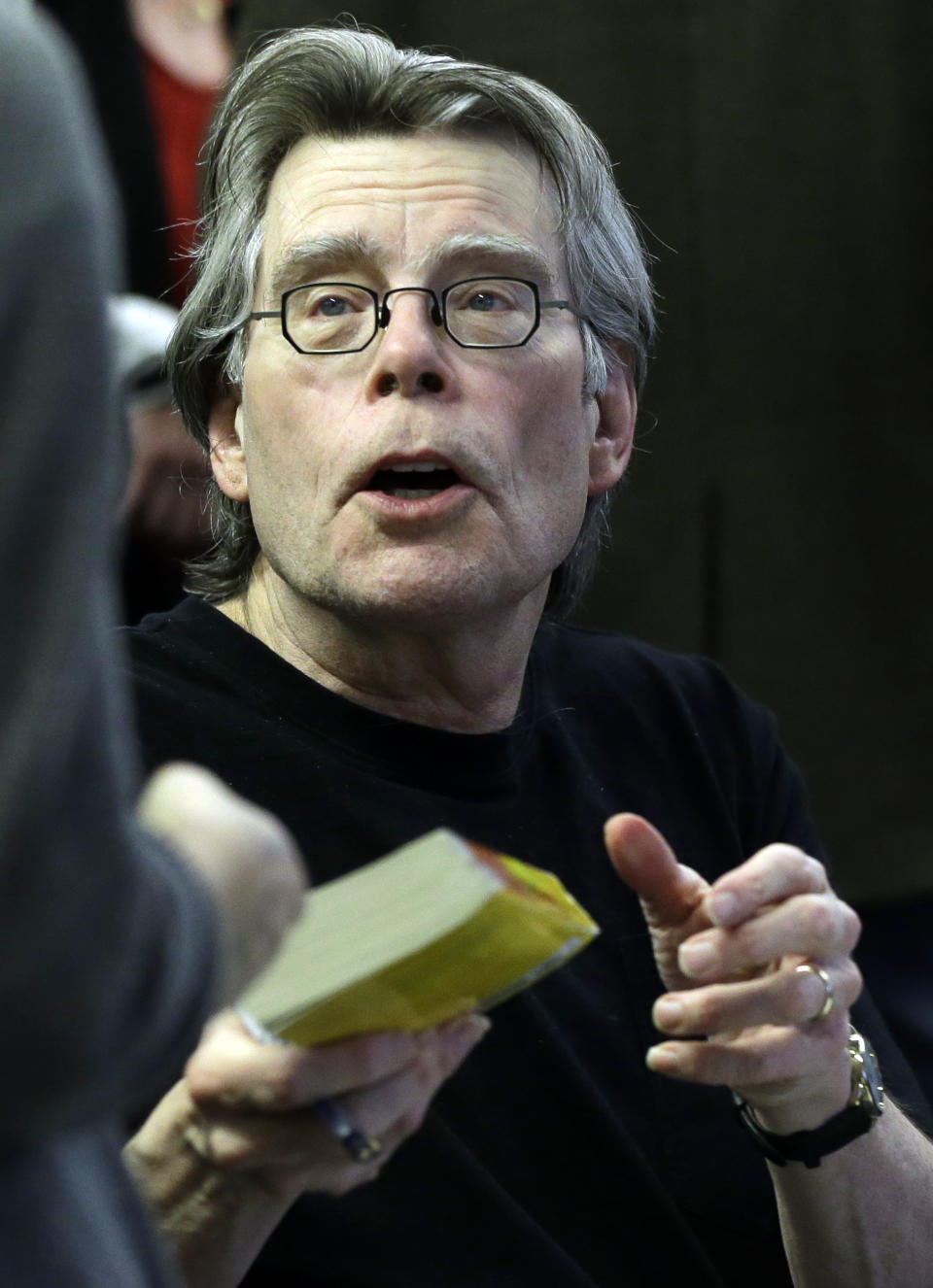 Novelist Stephen King hands back a book after signing it for a student at the University of Massachusetts-Lowell in Lowell, Mass., Friday, Dec. 7, 2012. (AP Photo/Elise Amendola)