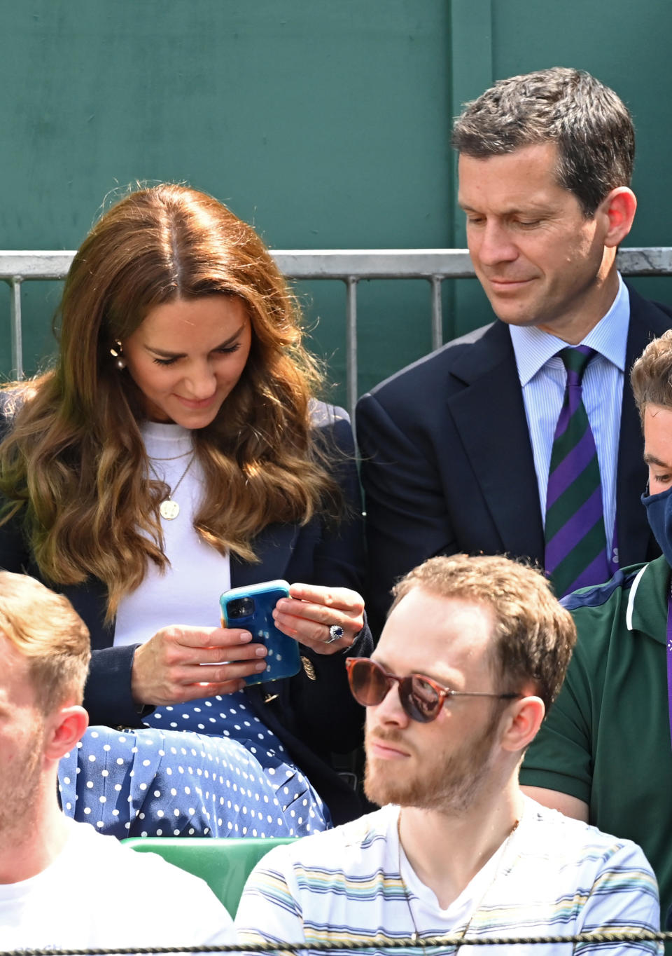 LONDON, ENGLAND - JULY 02: Catherine, Duchess of Cambridge checks her phone while attending Wimbledon Championships Tennis Tournament with Tim Henman at the All England Lawn Tennis and Croquet Club on July 02, 2021 in London, England. (Photo by Karwai Tang/WireImage)