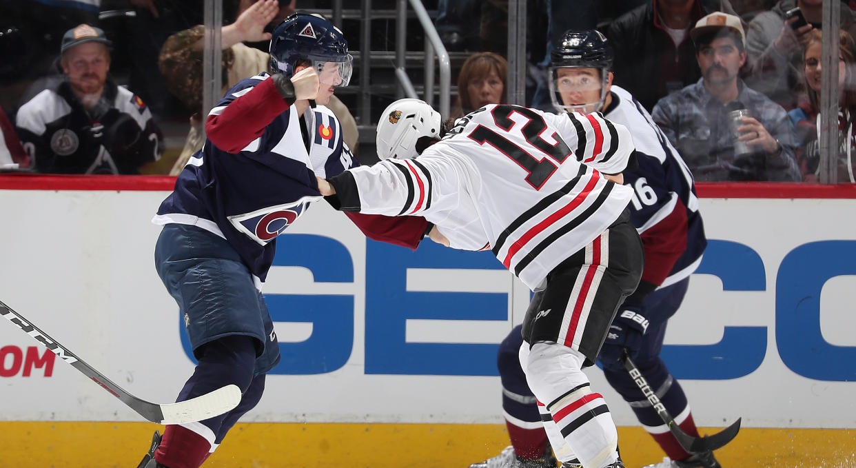 Samuel Girard of the Colorado Avalanche (left) throws hands with Alex DeBrincat of the Chicago Blackhawks at Pepsi Center on Saturday night. (Photo by Michael Martin/NHLI via Getty Images)