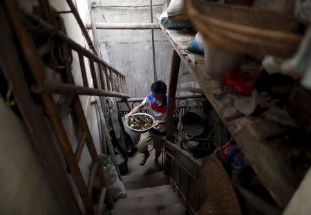 A man carries a bowl of dog meat dish as he has a gathering with his friends to eat dog meat and lychees to celebrate the upcoming local dog meat festival in Yulin, Guangxi Autonomous Region, June 21, 2015. REUTERS/Kim Kyung-Hoon