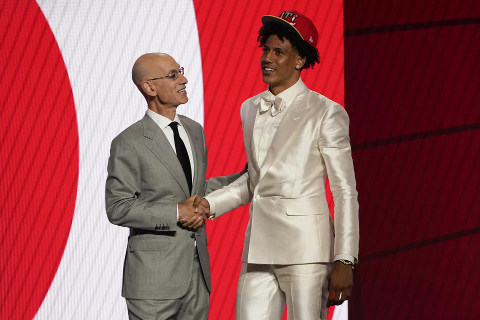 Jalen Johnson, right, greets NBA Commissioner Adam Silver after being selected 20th overall by the Atlanta Hawks during the NBA basketball draft, Thursday, July 29, 2021, in New York. (AP Photo/Corey Sipkin)