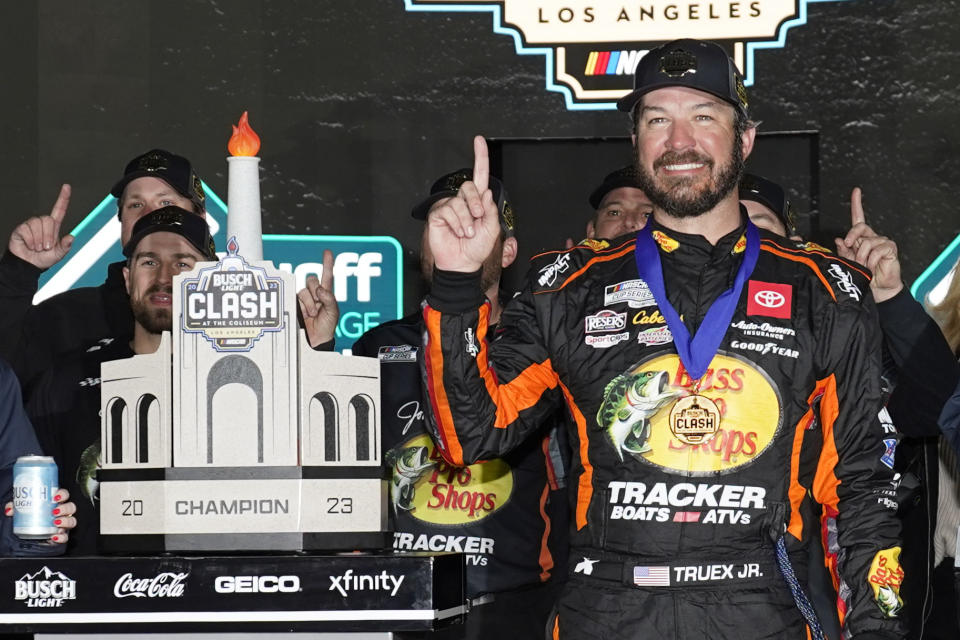 NASCAR Cup Series driver Martin Truex Jr. (19) poses for a photo with the championship trophy after winning a NASCAR exhibition auto race at Los Angeles Memorial Coliseum, Sunday, Feb. 5, 2023, in Los Angeles. (AP Photo/Ashley Landis)