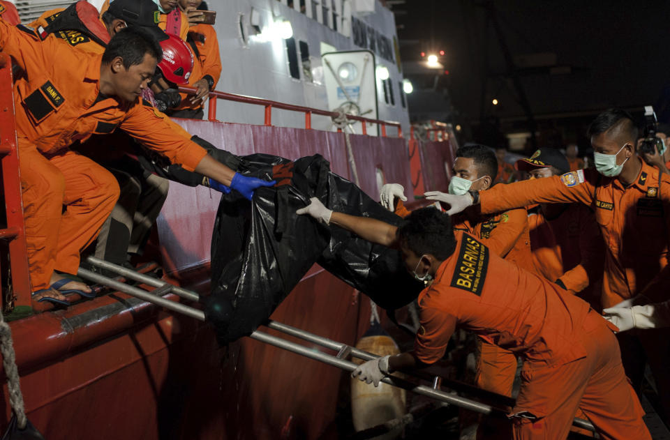 Rescuers hand body bags containing the remains of the victims of the crashed Lion Air jet to colleagues upon arrival at Tanjung Priok Port in Jakarta, Indonesia, Saturday, Nov. 3, 2018. The brand new Boeing 737 MAX 8 jet plunged into the Java Sea just minutes after takeoff from Jakarta early on Oct. 29, killing all of its passengers on board. (AP Photo/Fauzy Chaniago)