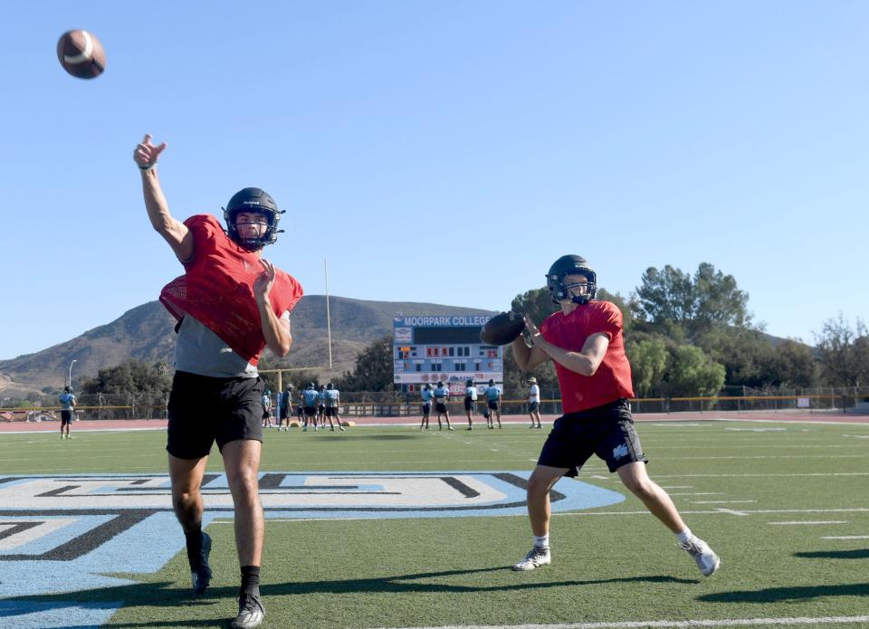 Quarterbacks Bennett Johnson, left, and Maccloud Crowton fire some passes during a Moorpark College football team practice on Wednesday. The Raiders open their season at Ventura College on Saturday night.