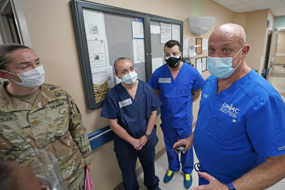 United Memorial Medical Center's Dr. Joseph Varon, right, talks with military members of the Urban Augmentation Medical Task Force Thursday, July 16, 2020, in Houston. Soldiers will treat COVID-19 patients inside a wing at the hospital as Texas receives help from across the country to deal with its coronavirus surge. (AP Photo/David J. Phillip)