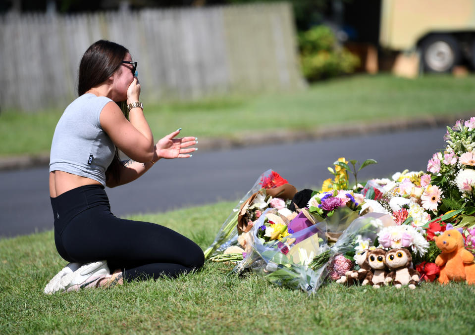 A friend of the victims named Korri Loader reacts at a makeshift shrine near the scene of the car fire. Source: AAP