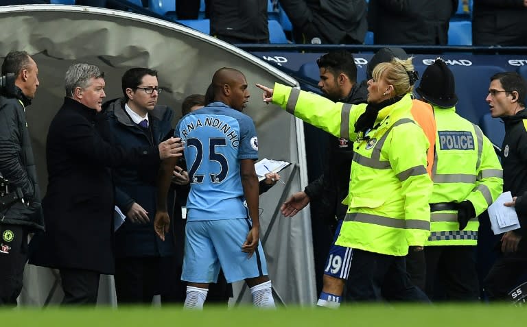 Manchester City's midfielder Fernandinho (C) is escorted off the pitch during a match against Chelsea on December 3, 2016