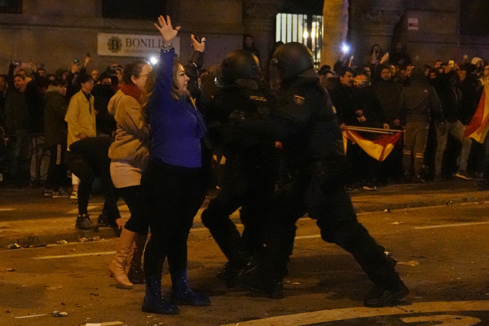 Agentes de la policía se enfrentan a manifestantes cerca de la sede nacional del Partido Socialista Obrero Español, en Madrid, el martes 7 de noviembre de 2023. (AP Foto/Paul White)