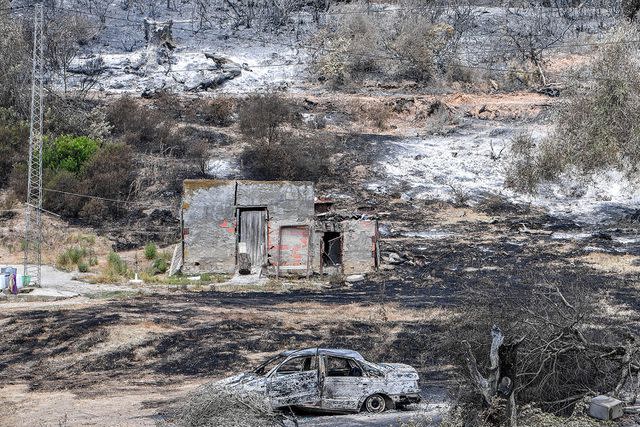 <p>FETHI BELAID/AFP via Getty Images</p> A burnt vehicle is pictured in the aftermath of a forest fire near the town of Melloula in northwestern Tunisia close to the border with Algeria on July 26, 2023.
