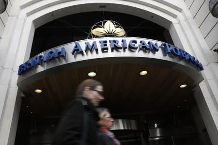 People walk past the British American Tobacco offices in London