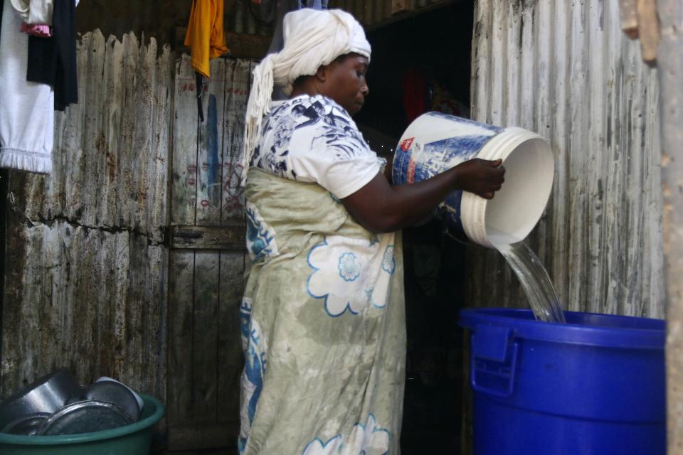 A woman empties her bucket of water in the district of M'tsamoudou, near Bandrele on the French Indian Ocean territory of Mayotte, Thursday Oct. 12, 2023. Water taps flow just one day out of three because of a drawn-out drought compounded by years of water mismanagement. (AP Photo/Gregoire Merot)