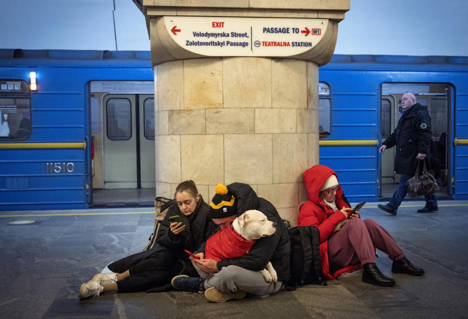 People sit in the subway station being used as a bomb shelter during a rocket attack in Kyiv, Ukraine, Thursday, Dec. 29, 2022. (AP Photo/Efrem Lukatsky)