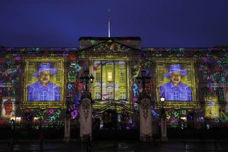 Illustrated self portraits by 200,000 children are projected onto Buckingham Palace to form portraits of Queen Elizabeth in central London April 19, 2012. REUTERS/Andrew Winning/File Photo