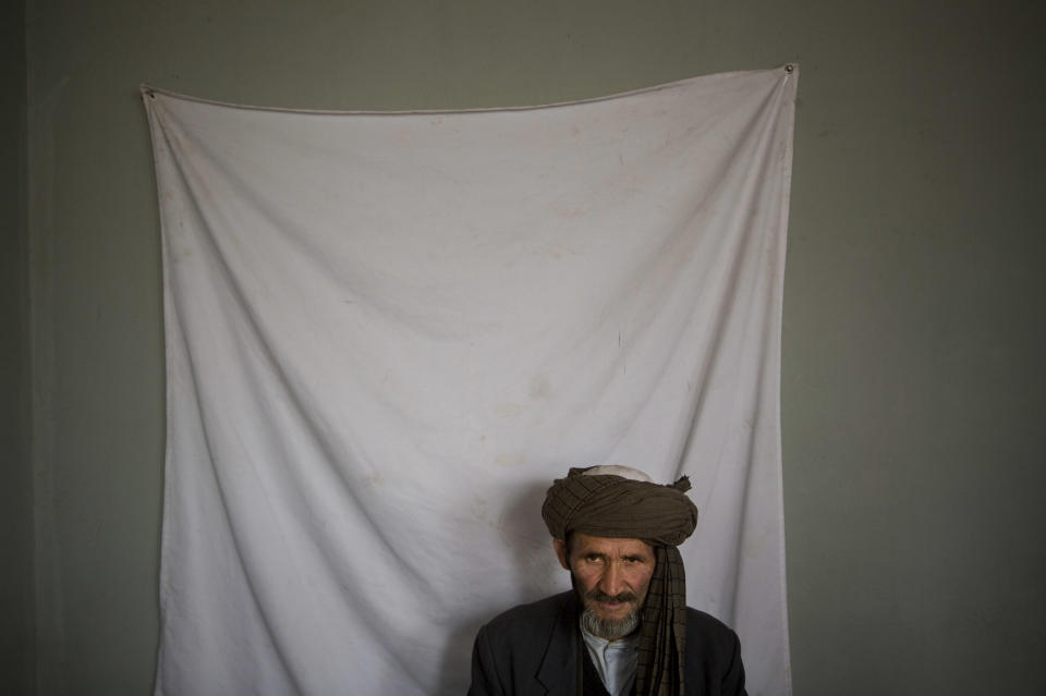 An Afghan man waits to have his picture taken for his registration card on the last day of voter registration for the upcoming presidential elections outside a school in Kabul, Afghanistan, Tuesday, April 1, 2014. Elections will take place on April 5, 2014. (AP Photo/Anja Niedringhaus)