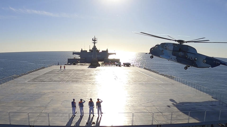 This image made from a video released on Wednesday, Jan. 13, 2021, by the Iranian Army shows a helicopter landing on Makran logistics vessel during a navy drill. Iran's navy began a short-range missile drill in the Gulf of Oman on Wednesday, state TV reported, amid heightened regional tensions over Tehran's nuclear program and a U.S. pressure campaign against the Islamic Republic. (Iranian Army via AP)