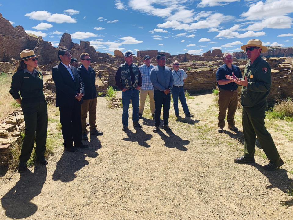In this photo provided by the Navajo Nation, Nathan Hatfield, chief of interpretation at Chaco Culture National Historical Park, speaks to Interior Secretary David Bernhardt, tribal leaders and others during a tour Tuesday, May 28, 2019 at the site about 95 miles northeast of Gallup, New Mexico. (Jared Touchin/Navajo Nation via AP)