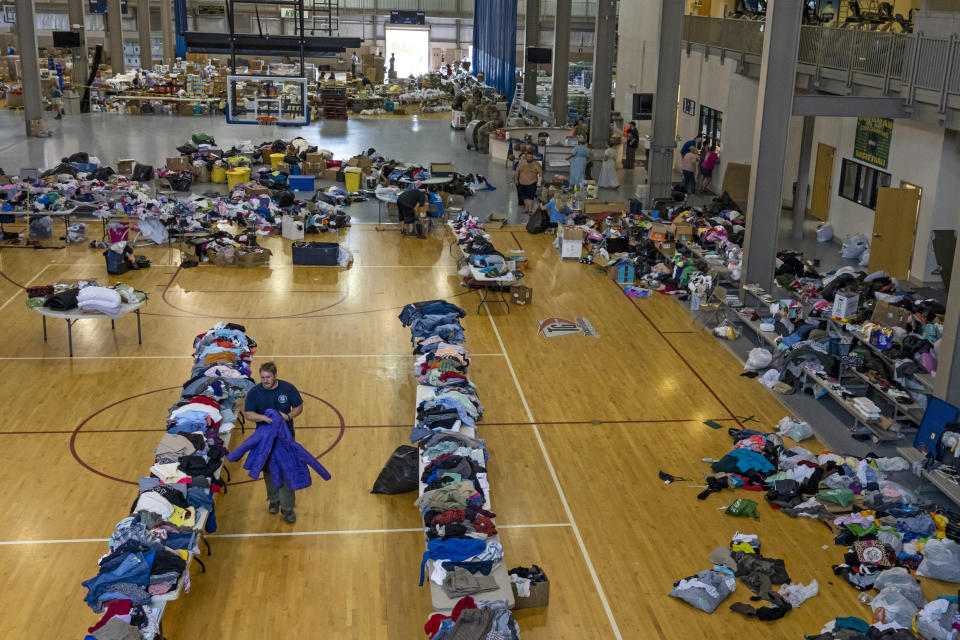 Image: A man organizes coats on the donation table at the Knott County Sportsplex on Aug. 2, 2022. (Michael Swensen for NBC news)