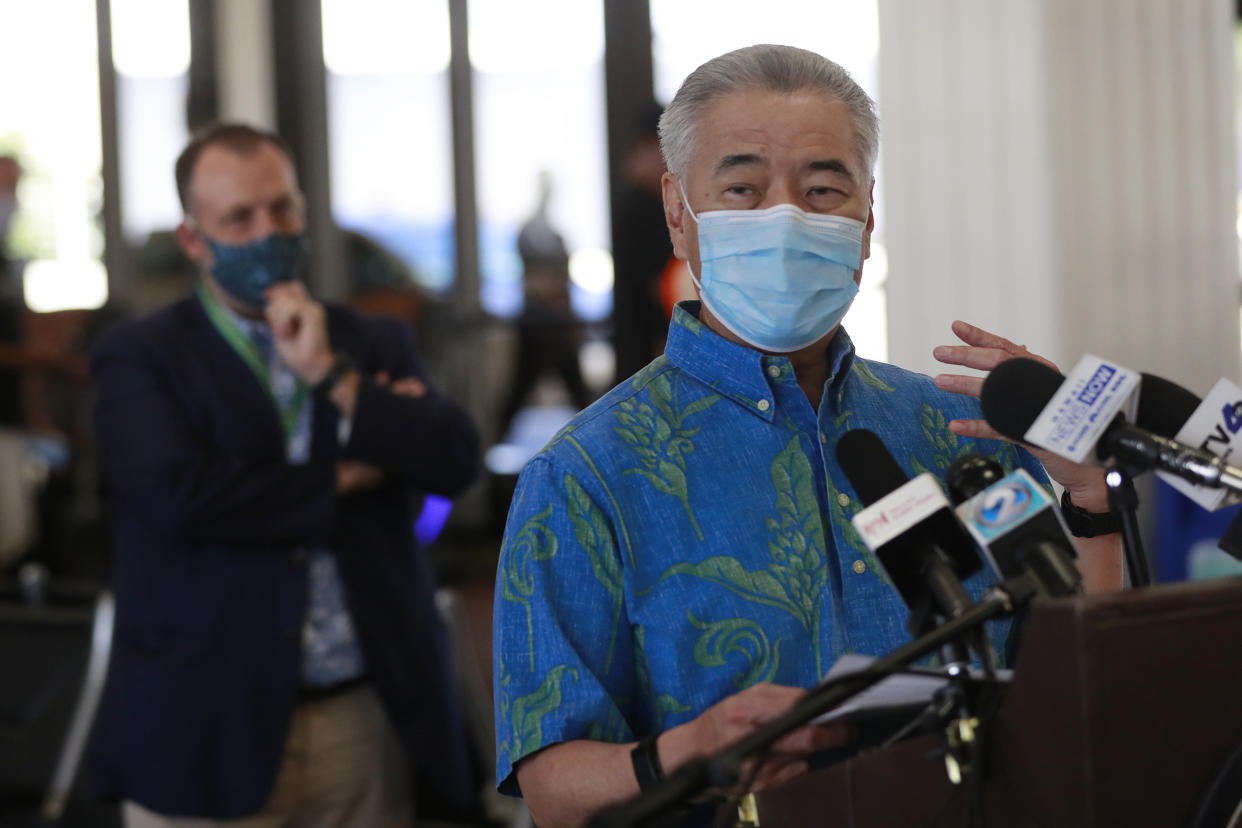 FILE - In this Oct. 15, 2020, file photo, Hawaii Gov. David Ige speaks at a news conference at the Daniel K. Inouye International Airport in Honolulu. As Hawaii struggles to control COVID-19 as the highly contagious delta variant spreads, Ige is asking people not to visit the islands and he wants visitors and residents to limit travel to essential purposes. (AP Photo/Marco Garcia, File)