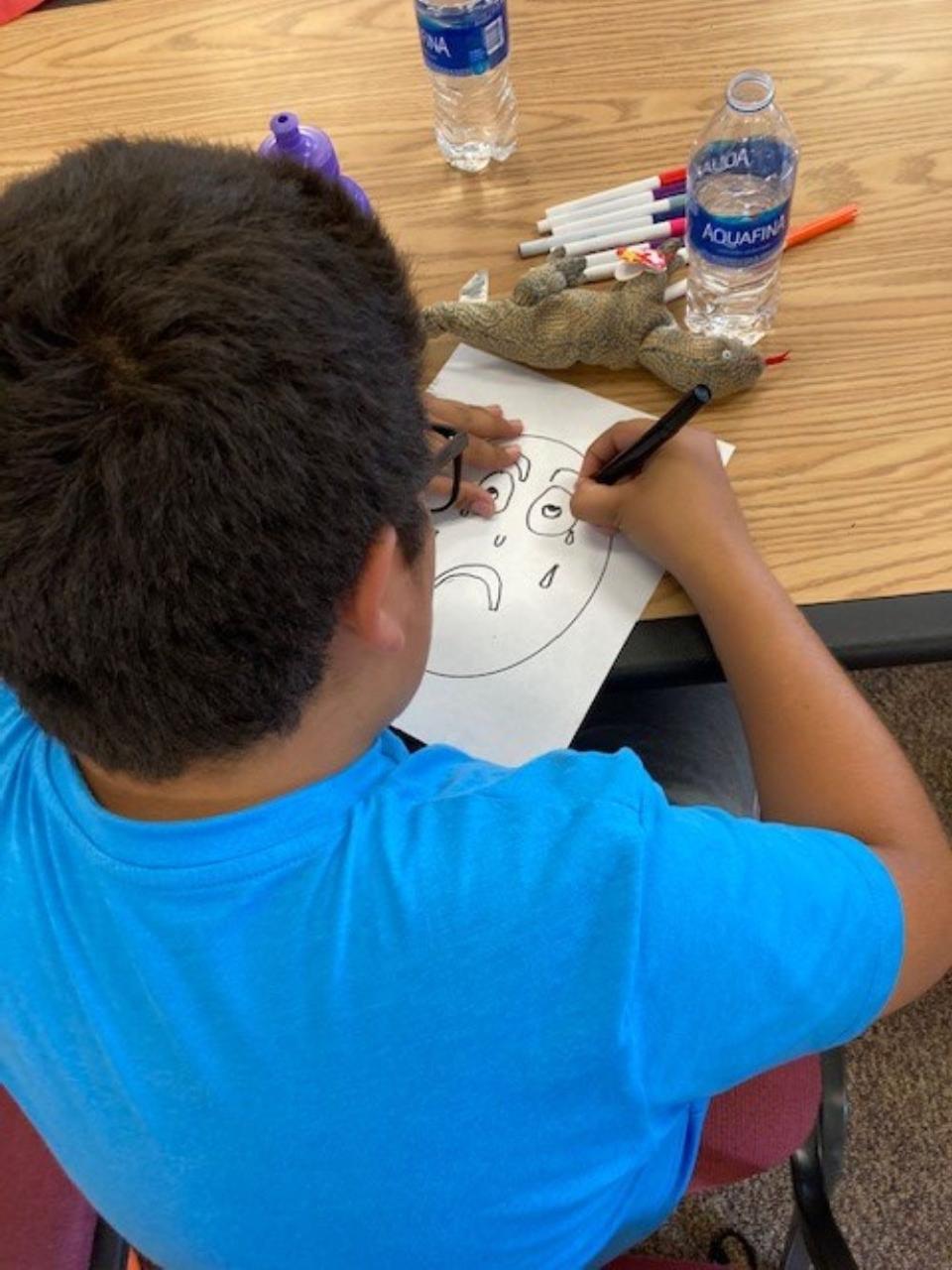 A boy draws a picture at "Good Grief!" kids camp. The first camp this summer will be held on June 10 in Canon City.