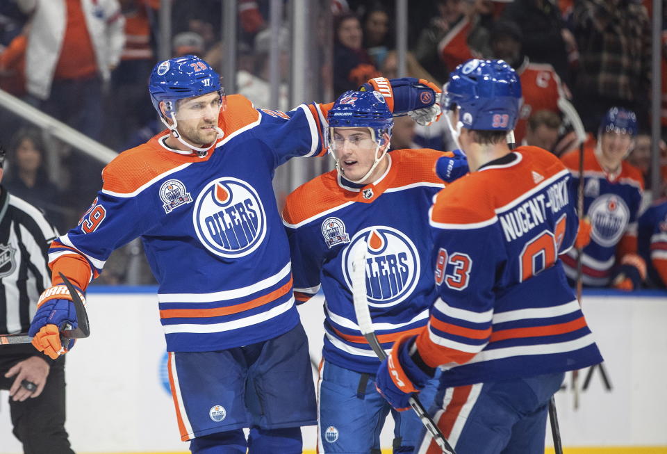 Edmonton Oilers' Leon Draisaitl (29), Tyson Barrie (22) and Ryan Nugent-Hopkins (93) celebrate a goal against the New Jersey Devils during the second period of an NHL hockey game Thursday, Nov. 3, 2022, in Edmonton, Alberta. (Jason Franson/The Canadian Press via AP)