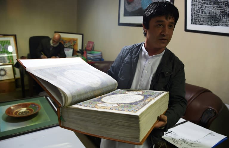 Afghan master miniature artist Abdull Sabur Omari shows a handmade Koran made with silk fabric at the Turquoise Mountain Foundation in Mourad Khani, in the old city section of Kabul