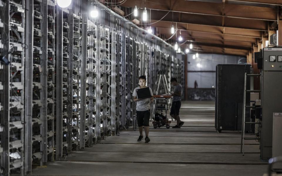 Technicians inspect bitcoin mining machines at a mining facility operated by Bitmain Technologies Ltd. in Ordos, Inner Mongolia - Qilai Shen /Bloomberg 