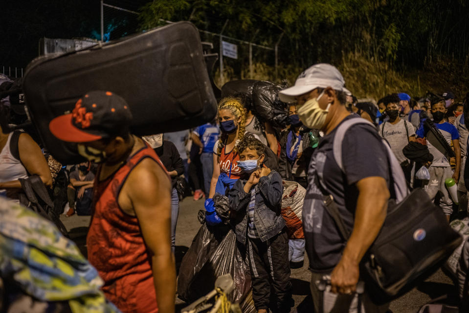 Migrantes venezolanos abordan un autobús para dirigirse a la frontera desde Bucaramanga, Colombia, el 20 de mayo de 2020. (Federico Rios/The New York Times)