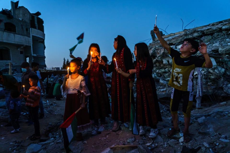 Palestinian children hold up candles and weep as they attend a candlelight vigil in Gaza City.