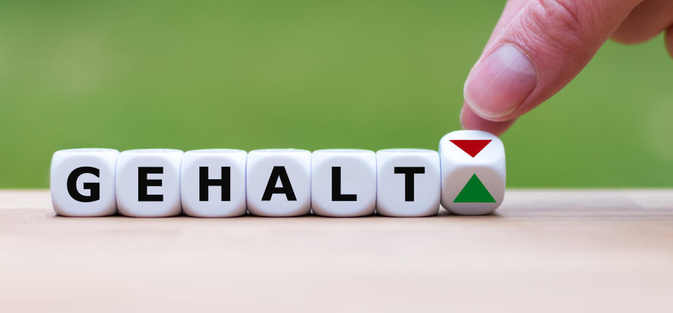 Hand is turning a dice and changes the direction of an arrow symbolizing that the personal salary ("Gehalt" in german) is going up instead of down (or vice versa)