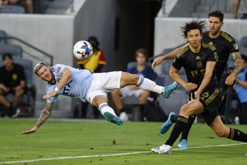 FC Dallas midfielder Paul Arriola, left, attempts to gain control of the ball from the air next to Los Angeles FC midfielder Ilie Sanchez, center, and defender Ryan Hollingshead during the first half of an MLS soccer match in Los Angeles, Wednesday, June 29, 2022. (AP Photo/Ringo H.W. Chiu)