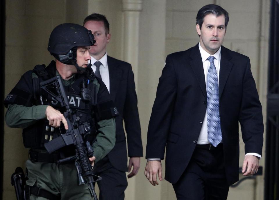 FILE - In this Dec. 5, 2016, file photo, Michael Slager, right, walks from the Charleston County Courthouse under the protection from the Charleston County Sheriff's Department after a mistrial was declared for his trial in Charleston, S.C. When nine black churchgoers in Charleston were massacred by Dylann Roof, a white man with Confederate sympathies, the city stayed calm and the victims’ families offered examples of grace and forgiveness. Roof’s guilty verdict came less than two weeks after a jury deadlocked in the case of Slager, a white ex-police officer charged with fatally shooting Walter Scott, a black man, as Scott tried to flee an April 2015 traffic stop. (AP Photo/Mic Smith, File)